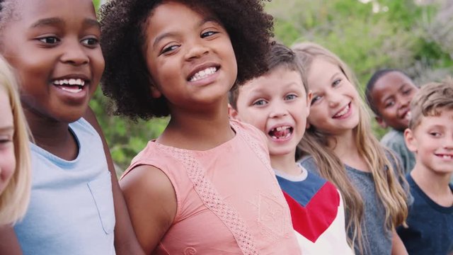 Portrait Of Children Standing On Climbing Frame With Friends In Park