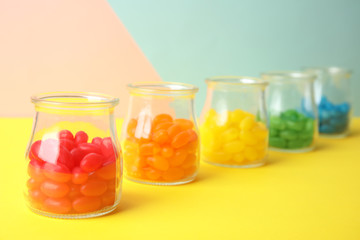 Fototapeta na wymiar Jars of colorful jelly beans on table