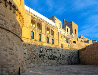 Obraz premium Medieval fortress wall and cozy hotel in the rays of the setting sun.