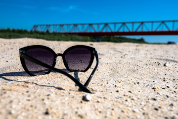 Fototapeta na wymiar sunglasses on the sandy beach