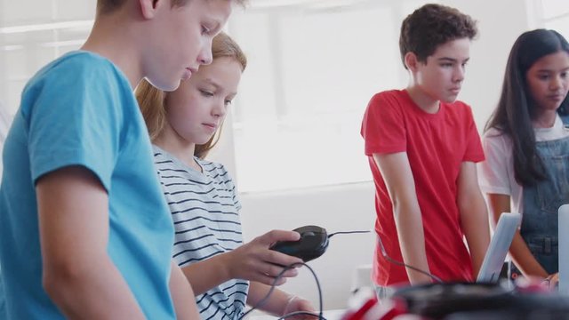Group Of Students In After School Computer Coding Class Learning To Program Robot Vehicle