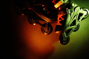 Close up view of roller skates inline skate or rollerblading on dark grunge background in neon blue...