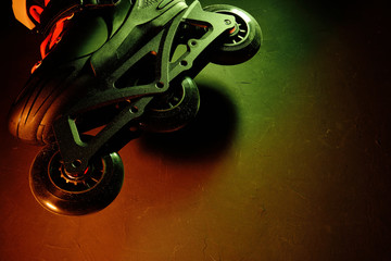 Close up view of roller skates inline skate or rollerblading on dark grunge background in neon blue...