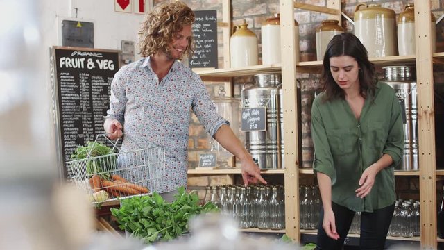 Young Couple Buying Fresh Fruit And Vegetables In Sustainable Plastic Free Grocery Store