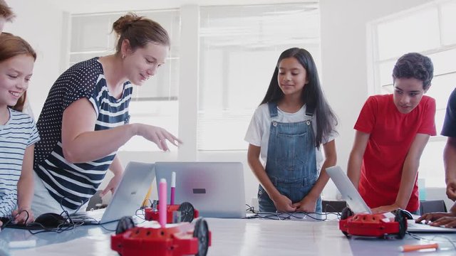 Excited Students Watching Robot Vehicle Move After Coding Lesson In Computer Programing Class