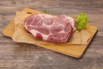 Raw pork steak over wooden board