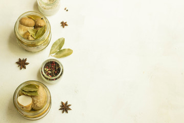 Pickled mushrooms and small jars of spice white background copy space