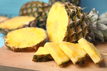 Cut fresh juicy pineapple on wooden board, closeup