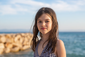 Fototapeta na wymiar young beautiful girl with wet hair in a swimsuit posing on the beach of the Adriatic Sea