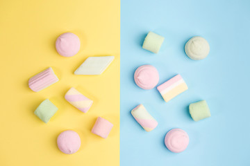 Marshmallows on blue and yellow backgrounds. Top view.
