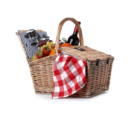 Wicker picnic basket with wine and different products on white background