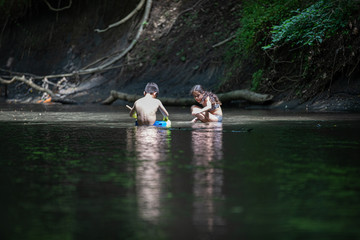 wBoy and girl sittin in river