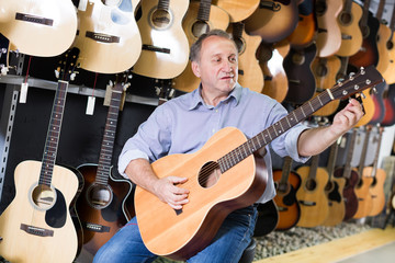 man is playing on  classic acoustic guitar