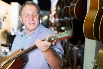 male is standing with modern guitar