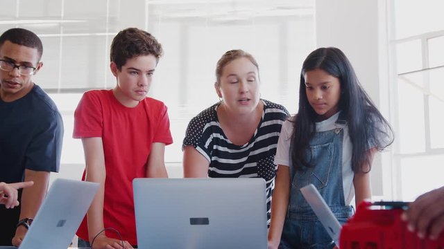 Students With Teachers In After School Computer Coding Class Learning To Program Robot Vehicle