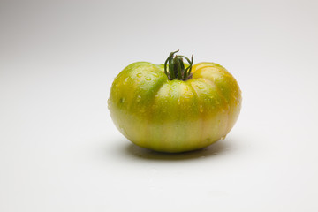 Tomates verdes, recién traidos del huerto. Hay personas que les gustan los tomates verdes. Tomate verde saludable, madurará fuera de la planta, quizás le afecte al sabor y a la calidad final del produ