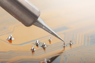 Soldering of electronic circuit board with electronic components. Soldering station. Engineers...