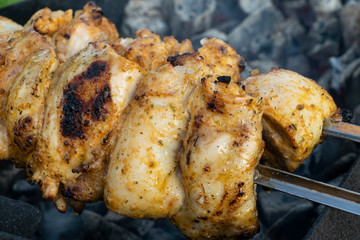 Marinated chicken kebab is cooked on the grill on the coals.
