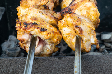 Marinated chicken kebab is cooked on the grill on the coals.