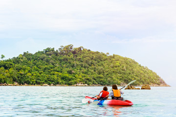 Fototapeta na wymiar Two woman tourists are mother and daughter travel by boat with a kayak under sunlight of summer at Ko Lipe enjoy the beautiful nature the sea and island in morning, Tarutao National Park, Satun, Thail