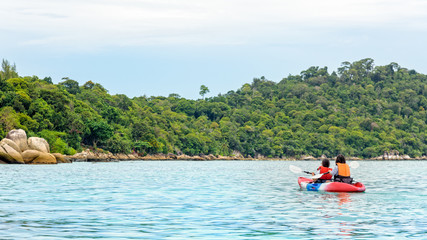Fototapeta na wymiar Two woman tourists are mother and daughter. Travel by boat with a kayak happy on the sea in the morning of summer at Ko Lipe island is the background, Tarutao National Park, Satun, Thailand