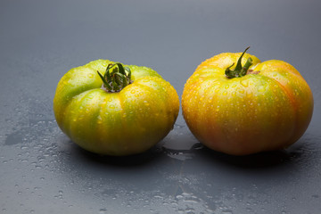 Tomates verdes y rojos, tomates verdes y maduros, recién traidos del huerto y preparados para ser cocinados o bien comidos crudos en una ensalada.