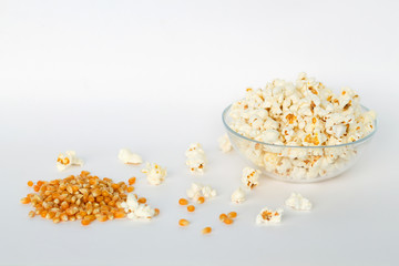 popcorn in a bowl with yellow corn grains isolated on white background