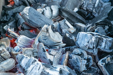 Barbecue grill with flaming and hot coal briquettes for barbecue, close-up