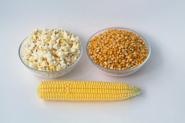 White popcorn and yellow corn in the bowls and corn cob on white background.