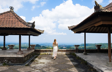 The girl walks beside a gazebo in an Asian style Bali