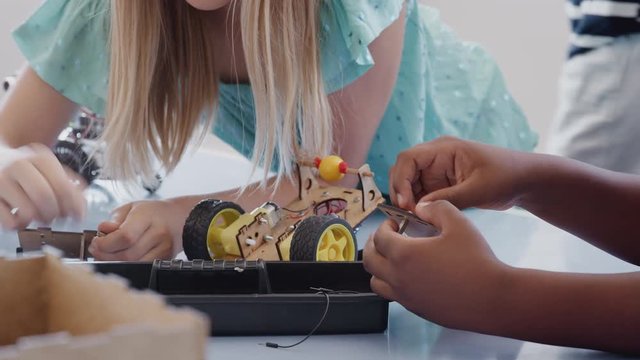 Two Students Building And Programing Robot Vehicle In After School Computer Coding Class 