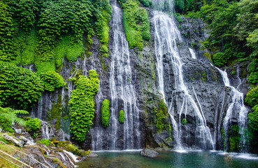 Fototapeta na wymiar Banyumala waterfall with cascades among the green tropical trees and plants in the North of the island of Bali, Indonesia