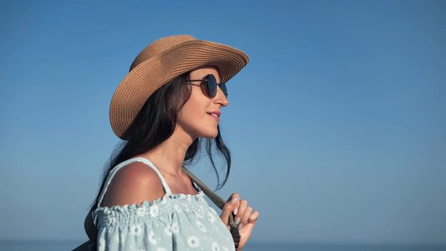 Pleasant travel hipster woman admiring beautiful seascape at sunset having positive emotion