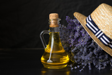 Fototapeta premium glass bottle with fragrant lavender oil bouquet of flowers hat.