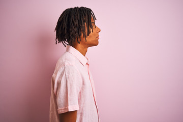 Afro american man with dreadlocks wearing elegant shirt standing over isolated pink background...