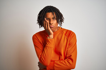 Afro american man with dreadlocks wearing orange sweater over isolated white background thinking looking tired and bored with depression problems with crossed arms.