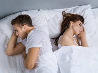 Unhappy young couple on the bed