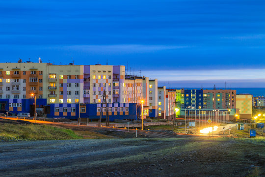 Evening cityscape. A small northern city in the Arctic. Pevek is the northernmost city in Russia. Multicolored buildings and bright street lighting at dusk. Pevek, Chukotka, Siberia, Russian Far East.
