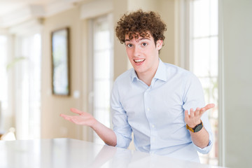Young business man with curly read head smiling cheerful with open arms as friendly welcome,...