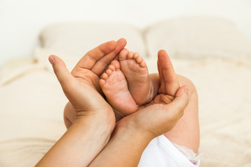 Baby feet in mother hands. Mom and her Child.