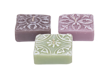 Candles isolated. Closeup of three colorful square candles with white pattern isolated on a white background. Decorations background.