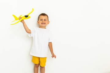 happy child toddler playing with yellow toy airplane
