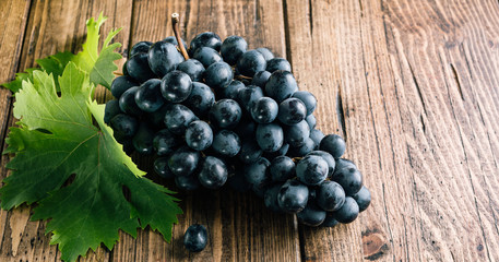 Fresh black grapes on wooden background, long banner