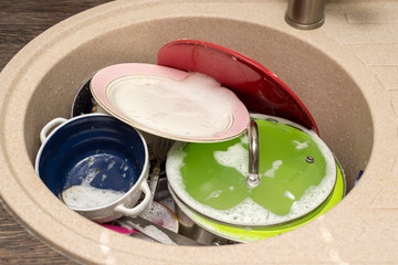Dirty dishes in the sink. Unwashed dishes and utensils in a kitchen sink. Washing dishes concept