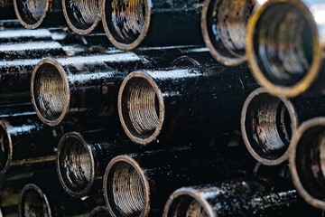 Drilling of oil and gas wells. Drill pipe inspection. Tubing for oil and gas listed on the pedestal out of the wells after washing and ready for inspection. Stack of casing laying on the deck.