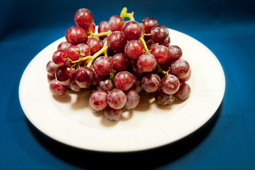  red grapes on a white plate