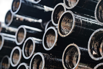 Drilling of oil and gas wells. Drill pipe inspection. Tubing for oil and gas listed on the pedestal out of the wells after washing and ready for inspection. Stack of casing laying on the deck. - obrazy, fototapety, plakaty