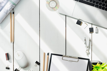 Architectural plans, pencil and ruler on the table. Laptop and workplace accessories. Place for...