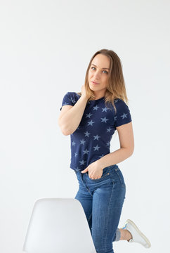 Pretty good looking stylish woman posing on white wall background. The concept of a strong independent purposeful young woman.