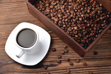 white coffee cup, morning side light coffee beans wooden box with coffee, top view natural wooden background